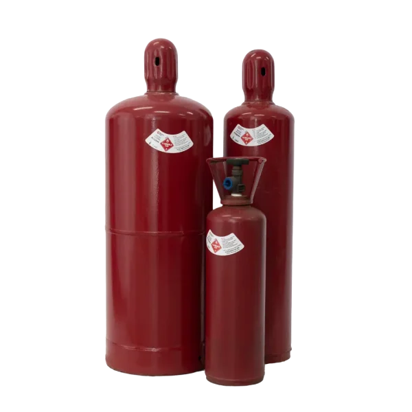 Three red gas cylinders of varying sizes, with hazard labels, stand together against a dark background.